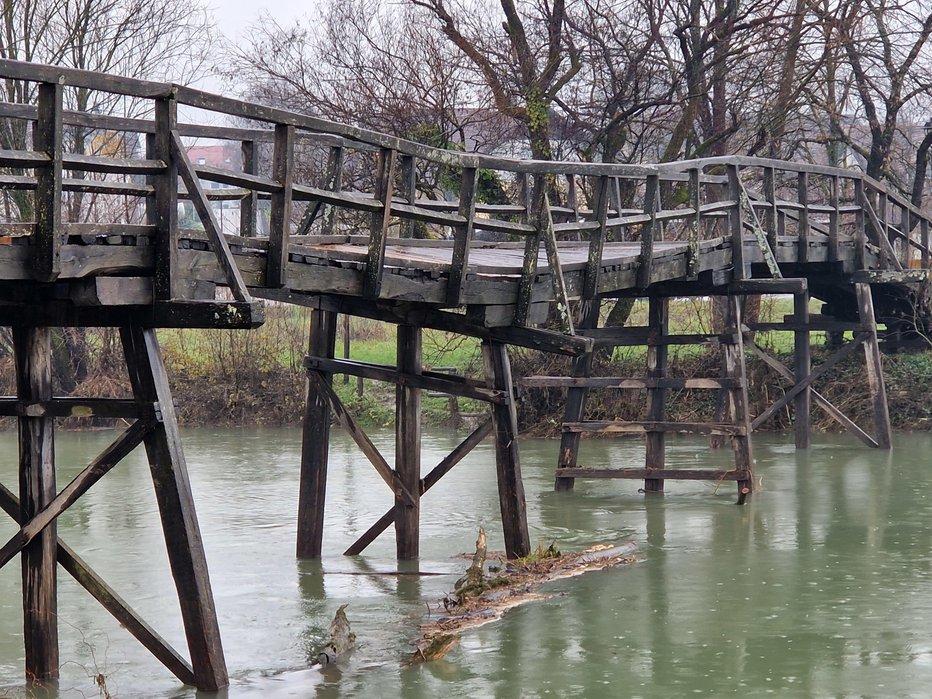 Fotografija: Eden od nosilnih stebrov je klonil pod silo naplavin, zato se je most povesil. FOTOGRAFIJE: Tanja Jakše Gazvoda
